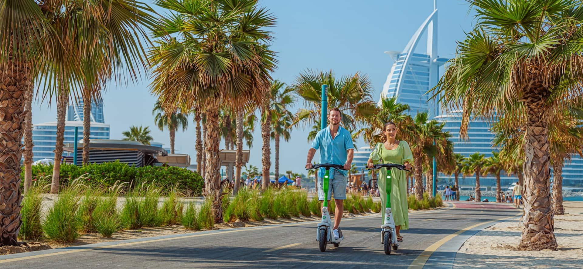 A palm-lined path in Dubai with Burj Al Arab in the background